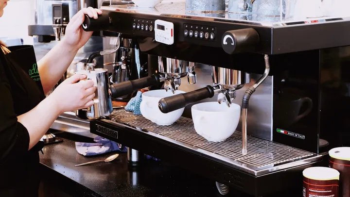 A barista making coffee at the espresso machine