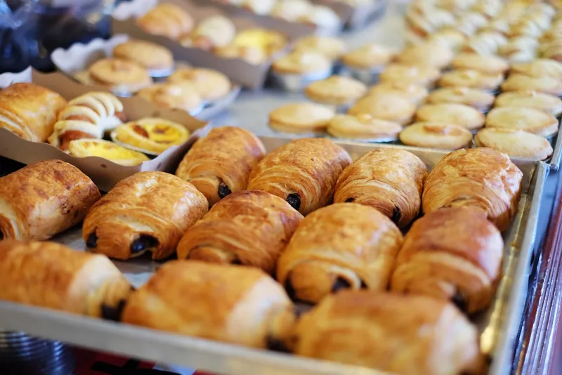 A pastry case filled with croissants and cakes